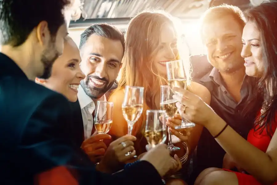Group enjoying social event with drinks using a minibus taxi hire service